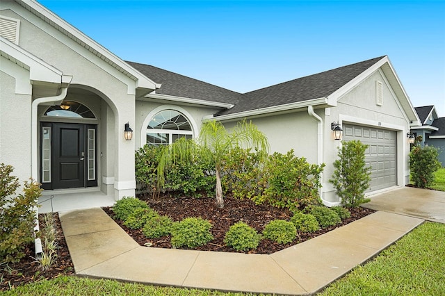 11539 Sunder Berry St, Hudson, FL 34667 - view of front of property featuring an attached garage, stucco siding, roof with shingles, and driveway