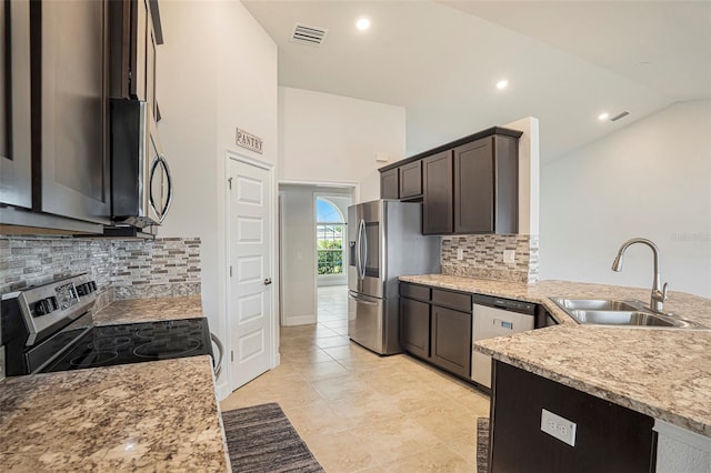11539 Sunder Berry St, Hudson, FL 34667 - kitchen featuring appliances with stainless steel finishes, vaulted ceiling, dark brown cabinetry, backsplash, and light stone counters