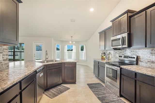 11539 Sunder Berry St, Hudson, FL 34667 - kitchen with appliances with stainless steel finishes, tasteful backsplash, dark brown cabinetry, light tile patterned flooring, and healthy amount of natural light
