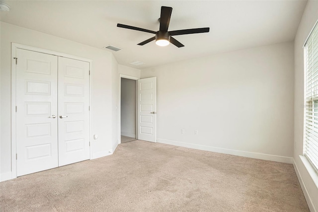 11539 Sunder Berry St, Hudson, FL 34667 - unfurnished bedroom featuring light colored carpet, a closet, multiple windows, and a ceiling fan
