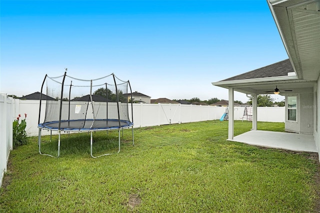 11539 Sunder Berry St, Hudson, FL 34667 - fenced backyard with a trampoline, a patio, ceiling fan, and a playground