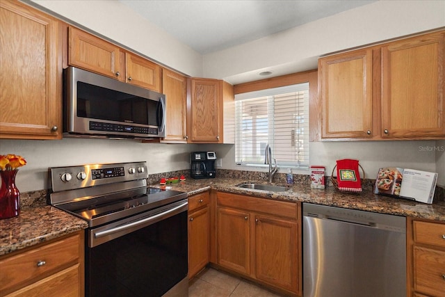 7003 Sunset Way Unit 6, St Pete Beach, FL 33706 - kitchen featuring stainless steel appliances, brown cabinets, dark stone counters, and light tile patterned floors