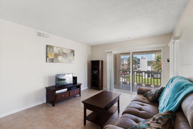 7003 Sunset Way Unit 6, St Pete Beach, FL 33706 - living room featuring a textured ceiling and light tile patterned floors
