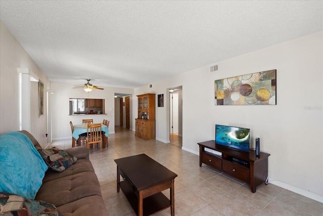7003 Sunset Way Unit 6, St Pete Beach, FL 33706 - living room featuring a ceiling fan, a textured ceiling, and light tile patterned floors