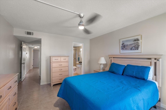 7003 Sunset Way Unit 6, St Pete Beach, FL 33706 - bedroom with light tile patterned floors, a ceiling fan, ensuite bathroom, and a textured ceiling