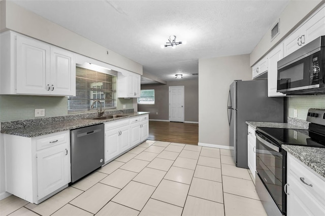607 Spring Blossom Ct, Brandon, FL 33511 - kitchen featuring stainless steel appliances, white cabinets, light tile patterned flooring, tasteful backsplash, and a textured ceiling