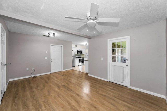 607 Spring Blossom Ct, Brandon, FL 33511 - unfurnished living room with light wood finished floors, a ceiling fan, and a textured ceiling