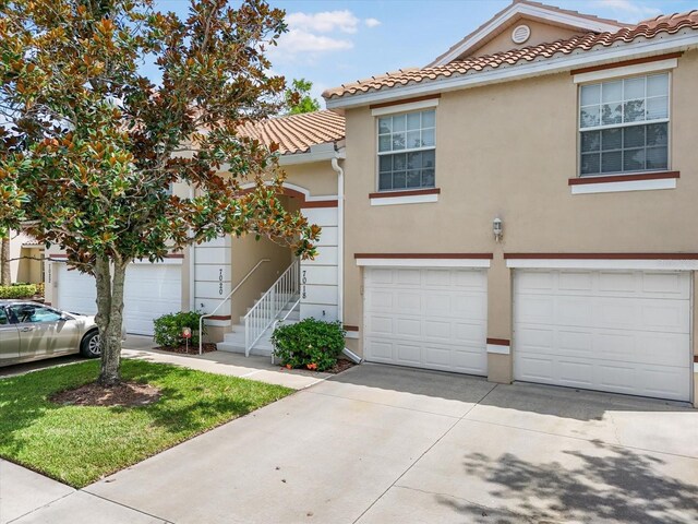7018 Scrub Jay Way, Bradenton, FL 34203 - mediterranean / spanish house with stucco siding, a tile roof, concrete driveway, and an attached garage