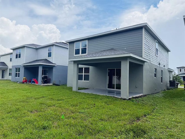 905 Rivers Crossing St, Clermont, FL 34714 - back of property with a patio area, a lawn, a shingled roof, and stucco siding
