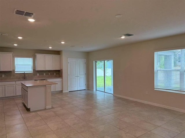 905 Rivers Crossing St, Clermont, FL 34714 - kitchen with decorative backsplash, light countertops, recessed lighting, white cabinetry, and a kitchen island