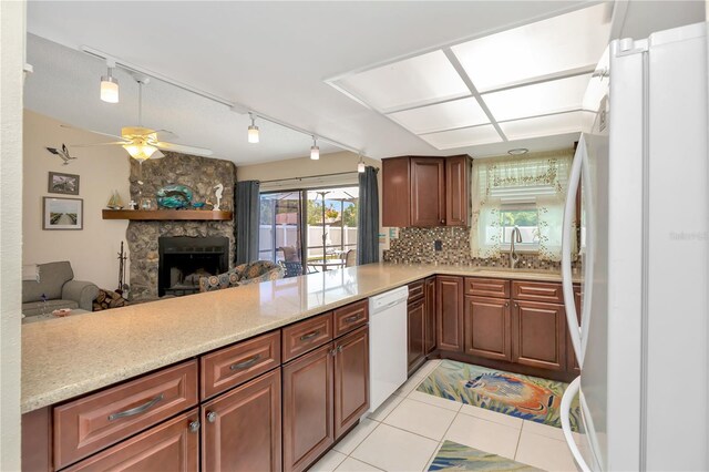 5319 Cordova Way S, Saint Petersburg, FL 33712 - kitchen with white appliances, rail lighting, a ceiling fan, a stone fireplace, and backsplash