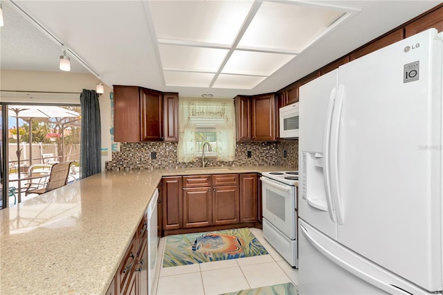 5319 Cordova Way S, Saint Petersburg, FL 33712 - kitchen featuring white appliances, backsplash, light tile patterned floors, light stone countertops, and a peninsula