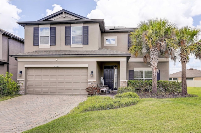 10146 Tuscan Sun Ave, Riverview, FL 33578 - traditional-style house with a front yard, stone siding, an attached garage, stucco siding, and driveway
