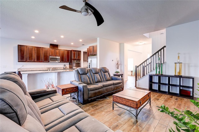 10146 Tuscan Sun Ave, Riverview, FL 33578 - living room featuring ceiling fan, light wood-style flooring, stairs, recessed lighting, and a textured ceiling