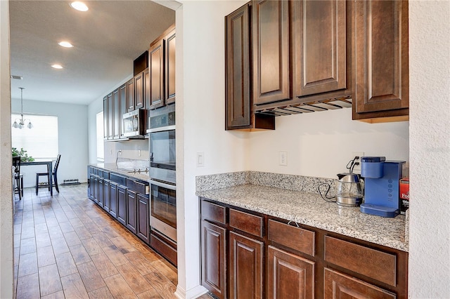 10146 Tuscan Sun Ave, Riverview, FL 33578 - kitchen featuring appliances with stainless steel finishes, recessed lighting, light wood-style floors, a chandelier, and light stone countertops