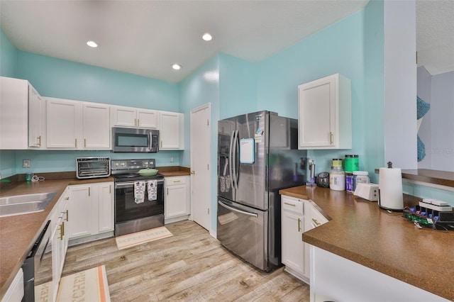 6314 Magnolia Trails Ln, Gibsonton, FL 33534 - kitchen featuring stainless steel appliances, dark countertops, white cabinets, light wood-style floors, and recessed lighting