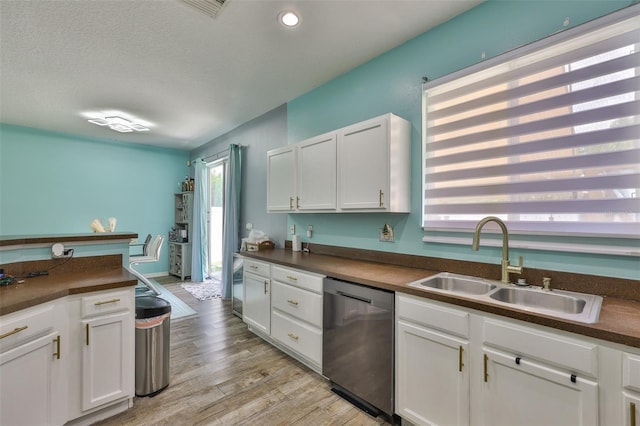 6314 Magnolia Trails Ln, Gibsonton, FL 33534 - kitchen with dishwasher, dark countertops, white cabinetry, light wood-style flooring, and a textured ceiling