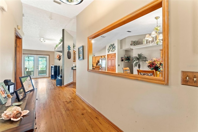 1008 Mallow Way, Brandon, FL 33510 - hallway with wood finished floors, lofted ceiling, french doors, and a chandelier