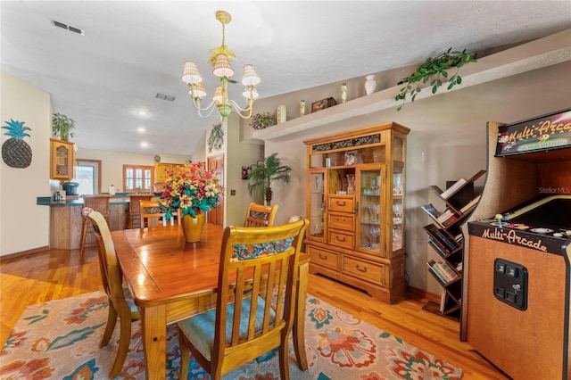 1008 Mallow Way, Brandon, FL 33510 - dining room with light wood-style floors and a chandelier