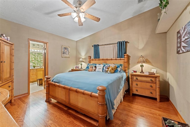 1008 Mallow Way, Brandon, FL 33510 - bedroom featuring light wood finished floors, ensuite bathroom, a textured ceiling, and a ceiling fan