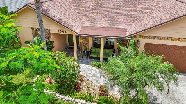 1008 Mallow Way, Brandon, FL 33510 - view of front of house featuring stone siding, a porch, and an attached garage