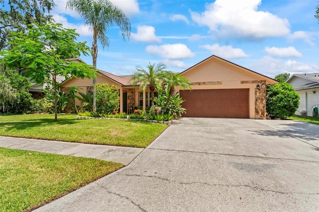 1008 Mallow Way, Brandon, FL 33510 - ranch-style home featuring a garage, concrete driveway, a front lawn, and stone siding