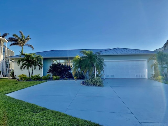 2569 Brazilia Ct, Punta Gorda, FL 33950 - view of front of property featuring driveway, a front lawn, a garage, a standing seam roof, and a metal roof