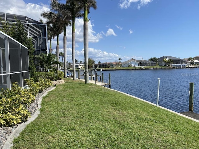 2569 Brazilia Ct, Punta Gorda, FL 33950 - dock area featuring a yard, a water view, glass enclosure, and a residential view