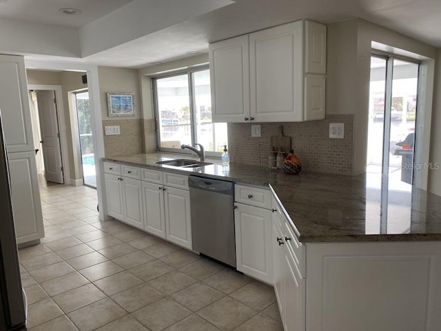 2569 Brazilia Ct, Punta Gorda, FL 33950 - kitchen featuring stainless steel dishwasher, decorative backsplash, light tile patterned floors, white cabinetry, and a peninsula