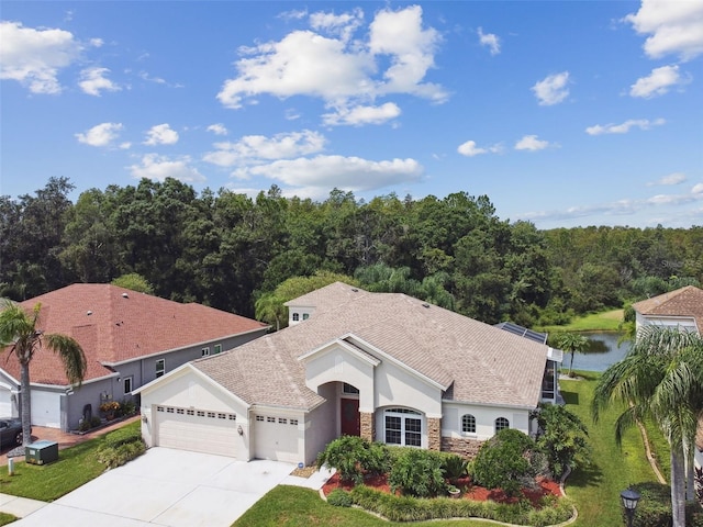5321 Silver Charm Ter, Wesley Chapel, FL 33544 - view of front of house featuring a garage, stucco siding, driveway, stone siding, and roof with shingles