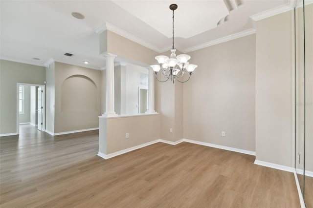 5321 Silver Charm Ter, Wesley Chapel, FL 33544 - empty room featuring light wood-style floors, a chandelier, crown molding, and ornate columns