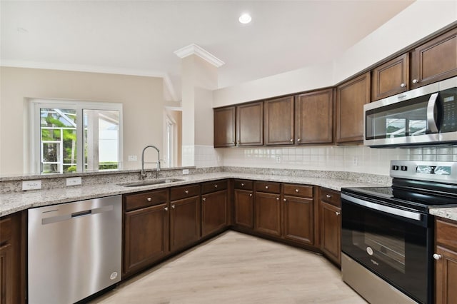 5321 Silver Charm Ter, Wesley Chapel, FL 33544 - kitchen featuring stainless steel appliances, light stone countertops, decorative backsplash, and crown molding