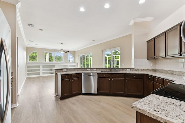 5321 Silver Charm Ter, Wesley Chapel, FL 33544 - kitchen featuring stainless steel appliances, a peninsula, crown molding, light wood finished floors, and light stone countertops