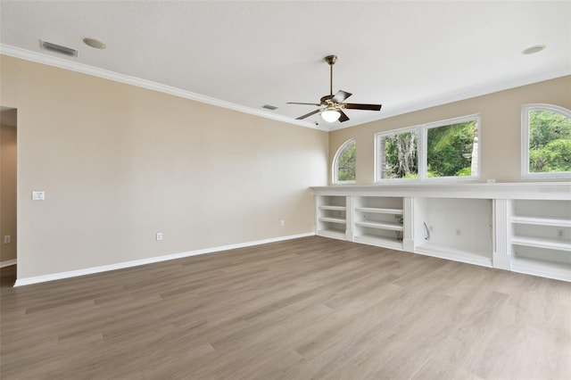 5321 Silver Charm Ter, Wesley Chapel, FL 33544 - empty room with ornamental molding, light wood finished floors, a ceiling fan, and built in features