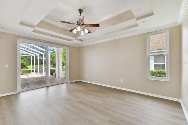 5321 Silver Charm Ter, Wesley Chapel, FL 33544 - empty room featuring a tray ceiling, ornamental molding, light wood finished floors, and a ceiling fan