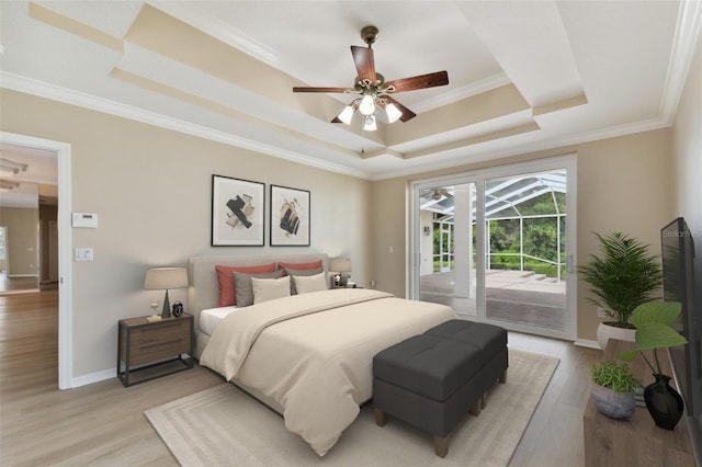 5321 Silver Charm Ter, Wesley Chapel, FL 33544 - bedroom featuring a tray ceiling, access to exterior, multiple windows, light wood-style flooring, and crown molding