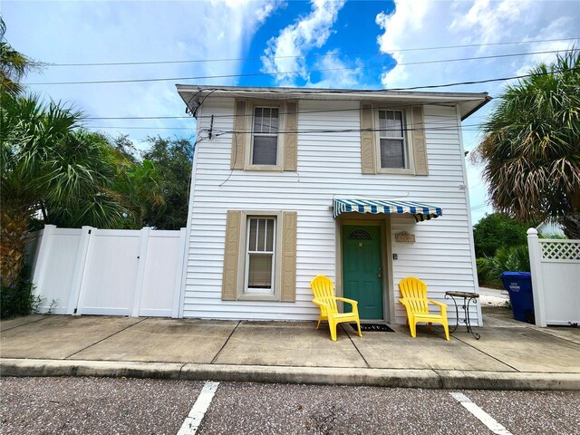 1205 Omaha Cir, Palm Harbor, FL 34683 - traditional-style home with a gate, a patio area, and uncovered parking