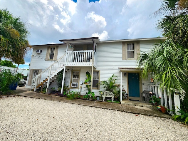 1205 Omaha Cir, Palm Harbor, FL 34683 - view of property featuring stairs, a wall unit AC, and cooling unit