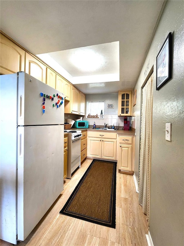 1205 Omaha Cir, Palm Harbor, FL 34683 - kitchen featuring freestanding refrigerator, white range with gas cooktop, light brown cabinetry, glass insert cabinets, and a textured wall
