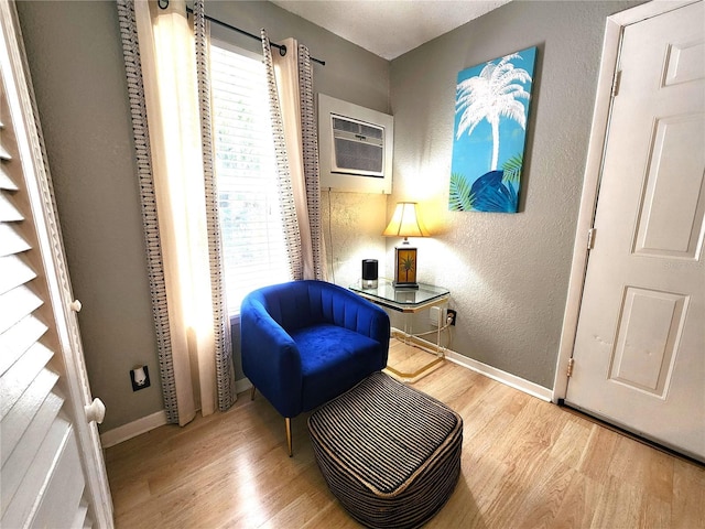 1205 Omaha Cir, Palm Harbor, FL 34683 - sitting room with wood finished floors, plenty of natural light, a wall mounted AC, and a textured wall