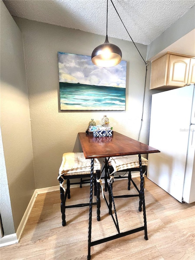 1205 Omaha Cir, Palm Harbor, FL 34683 - dining room featuring light wood-style flooring and a textured ceiling