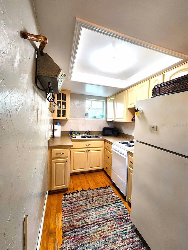 1205 Omaha Cir, Palm Harbor, FL 34683 - kitchen with white appliances, light wood-style flooring, and light brown cabinets