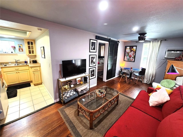 1205 Omaha Cir, Palm Harbor, FL 34683 - living area featuring a barn door, a wall mounted air conditioner, a ceiling fan, dark wood-style floors, and recessed lighting