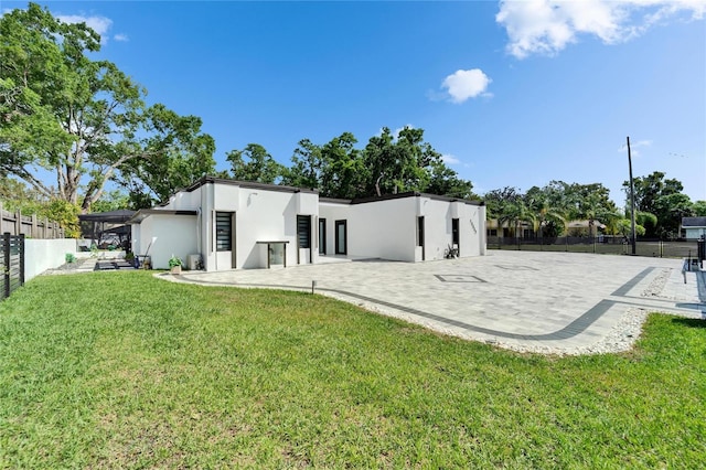 18852 Tracer Dr, Lutz, FL 33549 - rear view of house with stucco siding, a fenced backyard, and a patio