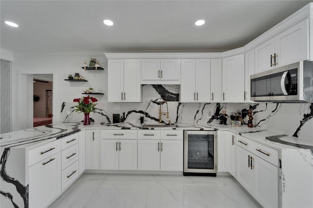 18852 Tracer Dr, Lutz, FL 33549 - kitchen with wine cooler, stainless steel microwave, a peninsula, ornamental molding, and white cabinetry