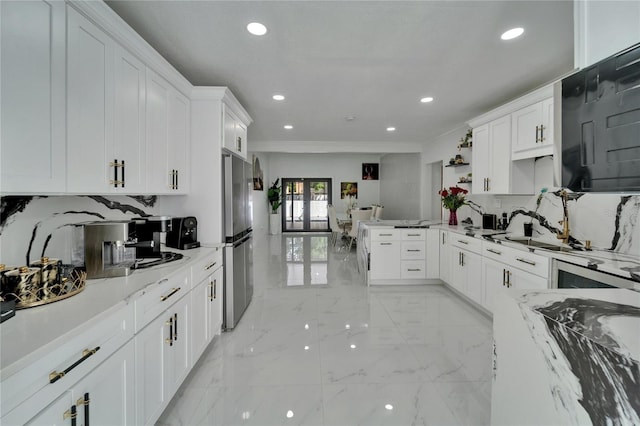 18852 Tracer Dr, Lutz, FL 33549 - kitchen featuring light marble finish flooring, a peninsula, crown molding, white cabinets, and freestanding refrigerator