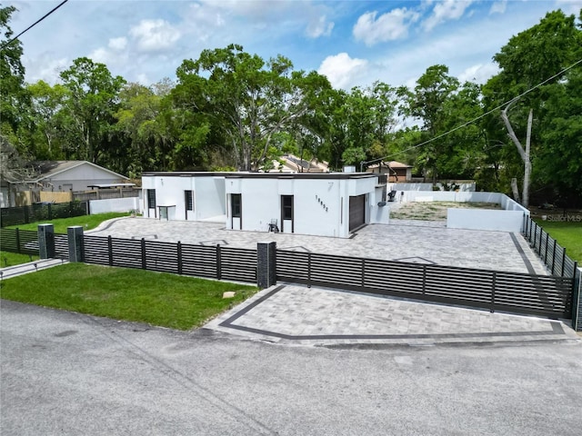 18852 Tracer Dr, Lutz, FL 33549 - contemporary house with a fenced front yard, a garage, driveway, and stucco siding
