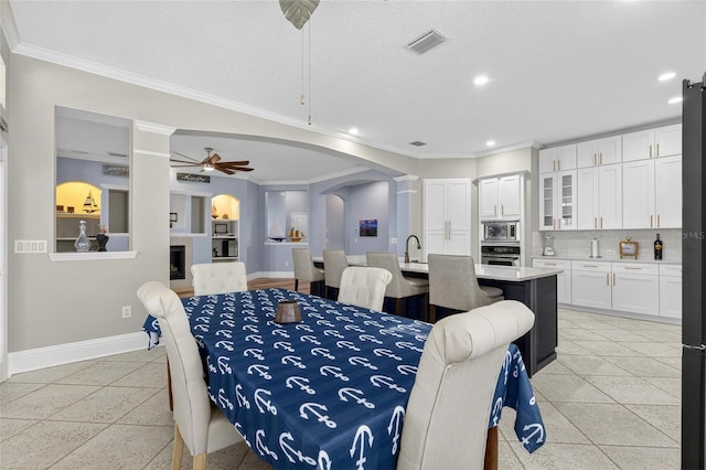 5720 Tortoise Pl, Apollo Beach, FL 33572 - dining room with arched walkways, crown molding, recessed lighting, ceiling fan, and decorative columns