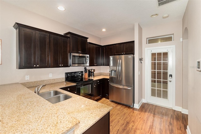 1395 Alston Bay Blvd, Apopka, FL 32703 - kitchen with appliances with stainless steel finishes, light wood-style floors, dark brown cabinets, light stone counters, and recessed lighting
