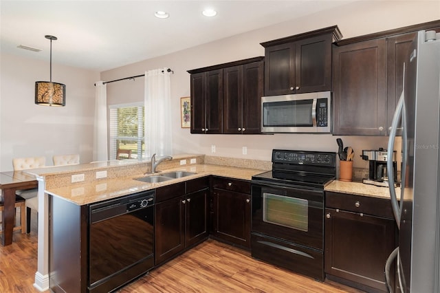 1395 Alston Bay Blvd, Apopka, FL 32703 - kitchen with black appliances, light wood-type flooring, a peninsula, dark brown cabinetry, and recessed lighting